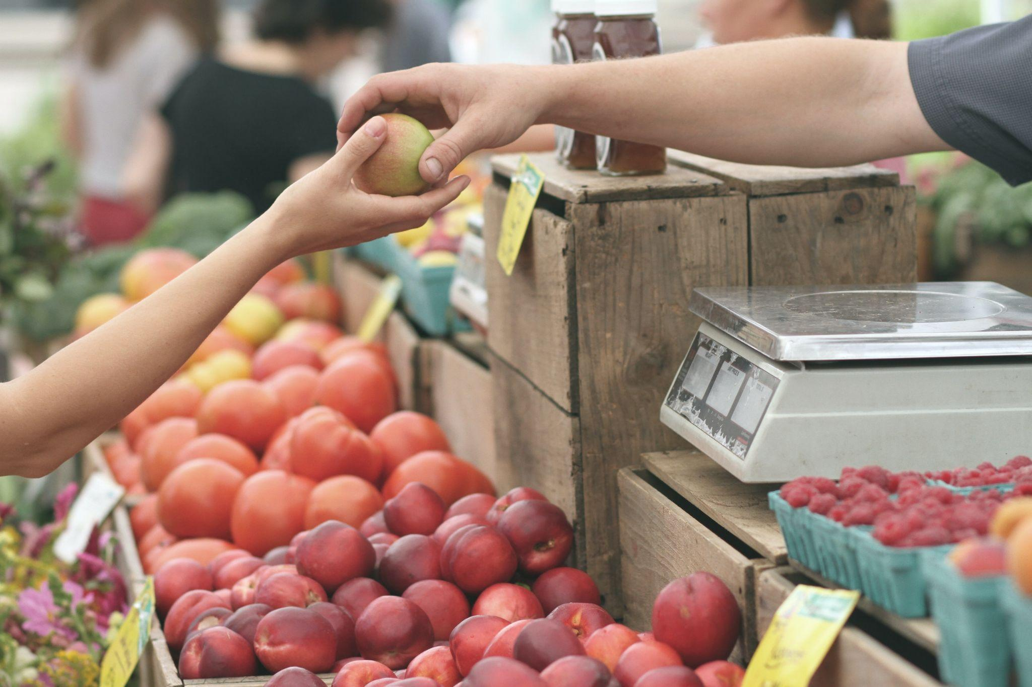 A fruit seller giving fruit to their customer